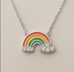 Collar Arcoíris Plateado Collar plateado con dije de arcoíris esmaltado en colores vivos y nubes con cristales brillantes, símbolo de alegría y esperanza.