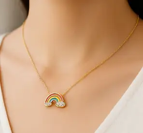 Collar dorado con dije de arcoíris esmaltado en colores vivos y nubes con cristales brillantes, símbolo de alegría y esperanza.
