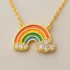 Collar dorado con dije de arcoíris esmaltado en colores vivos y nubes con cristales brillantes, símbolo de alegría y esperanza.